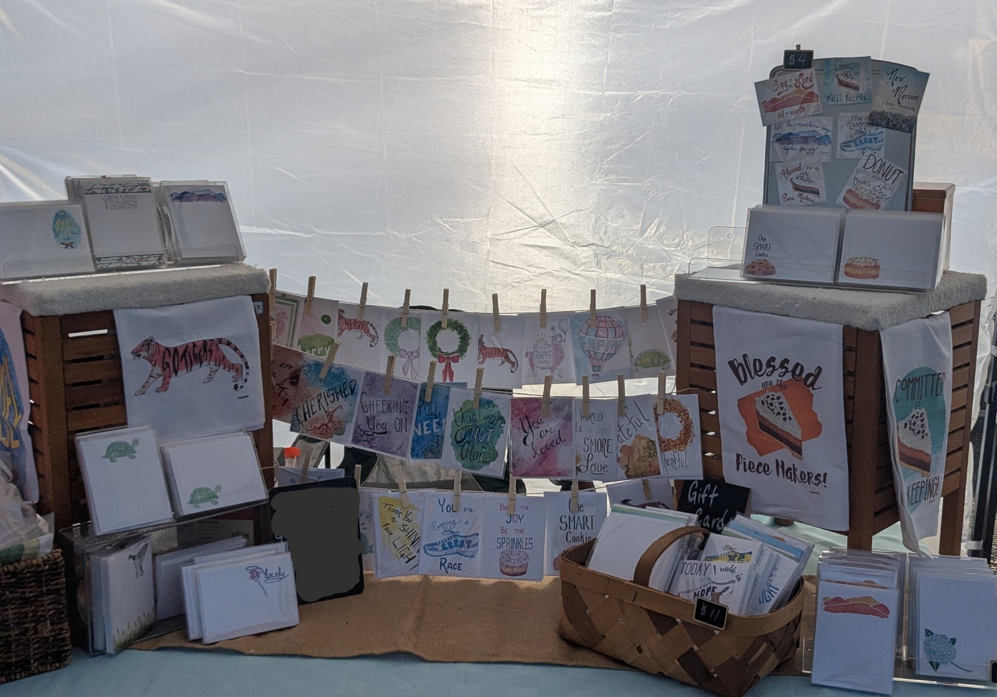 Display of greeting cards and stationery items on a table with a white backdrop